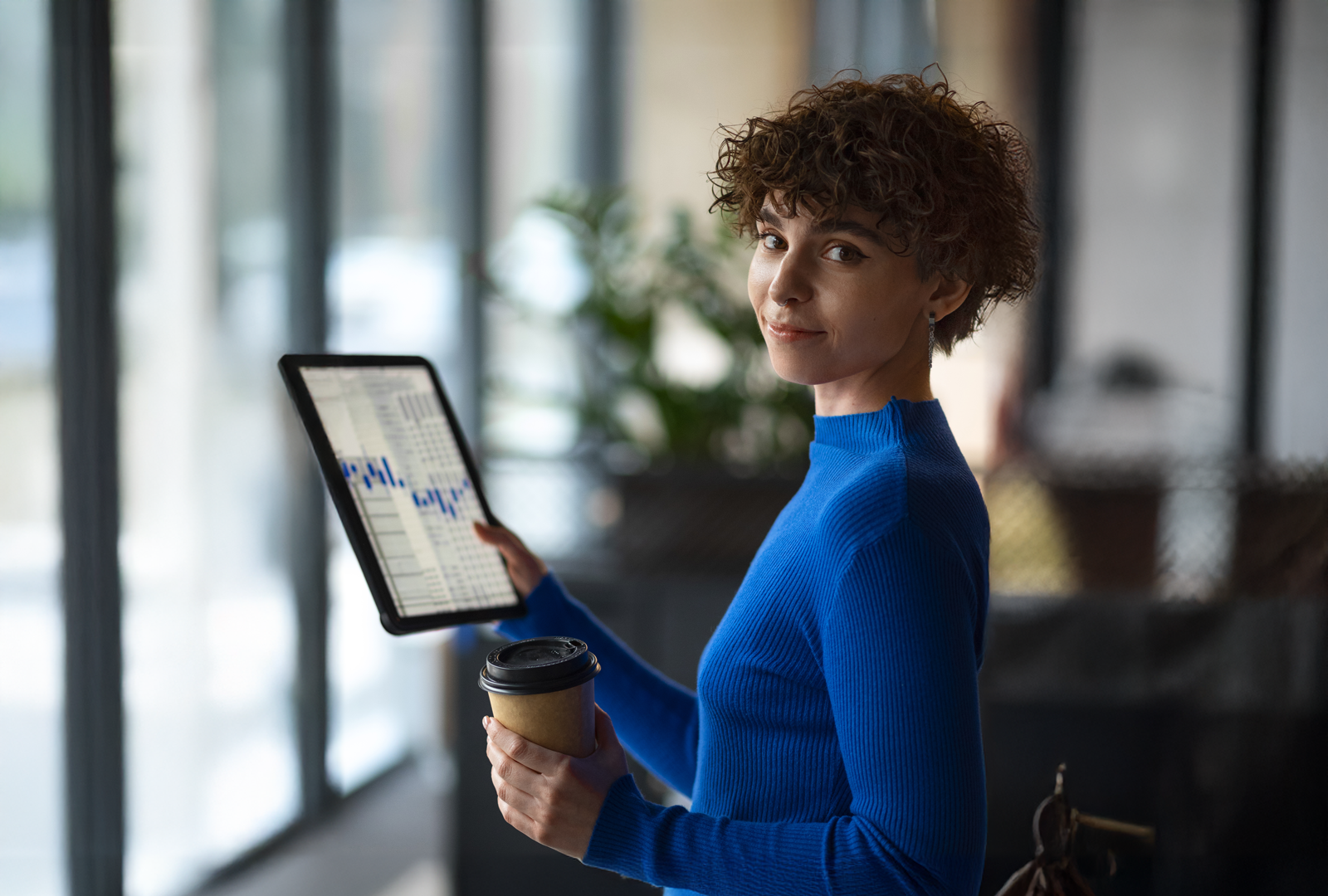 Female holding a tablet device with data graph displayed on the screen